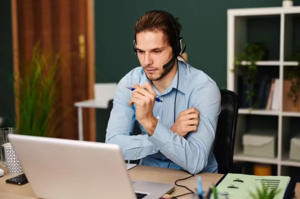 Remote support professional wearing a headset at a laptop